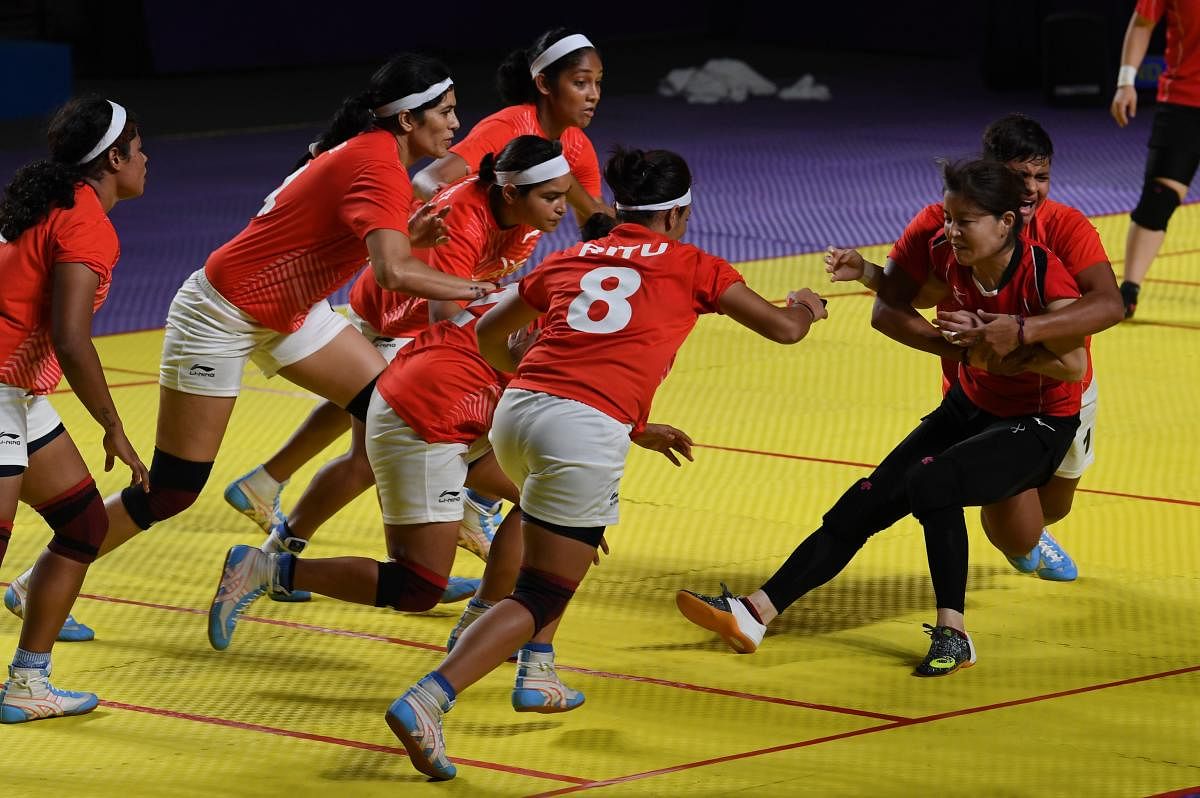 India's players (in white shorts) tackle a Japan player (in black shorts) during the women's team Group A match between India and Japan at the 2018 Asian Games in Jakarta. (AFP Photo)