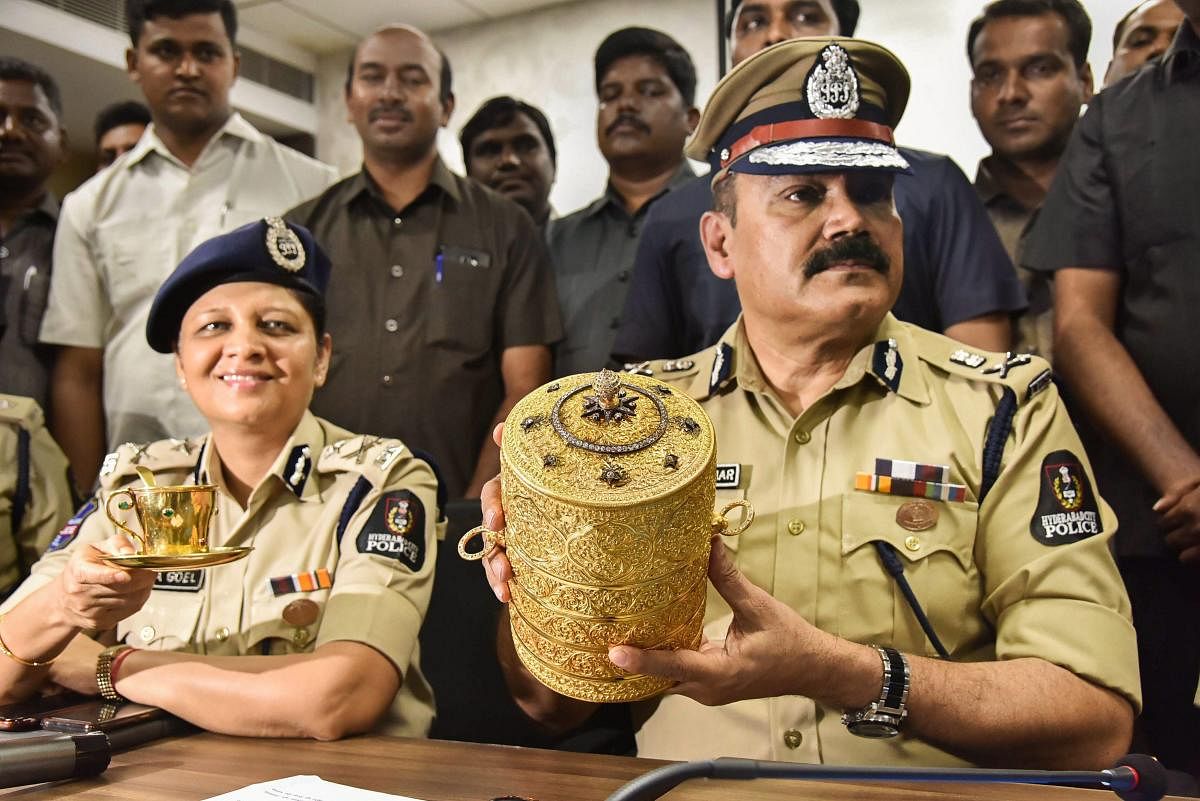 Police Commissioner Anjani Kumar along with a senior police officer shows the three-tier golden tiffin box and a golden cup after their recovery, in Hyderabad on Tuesday. PTI