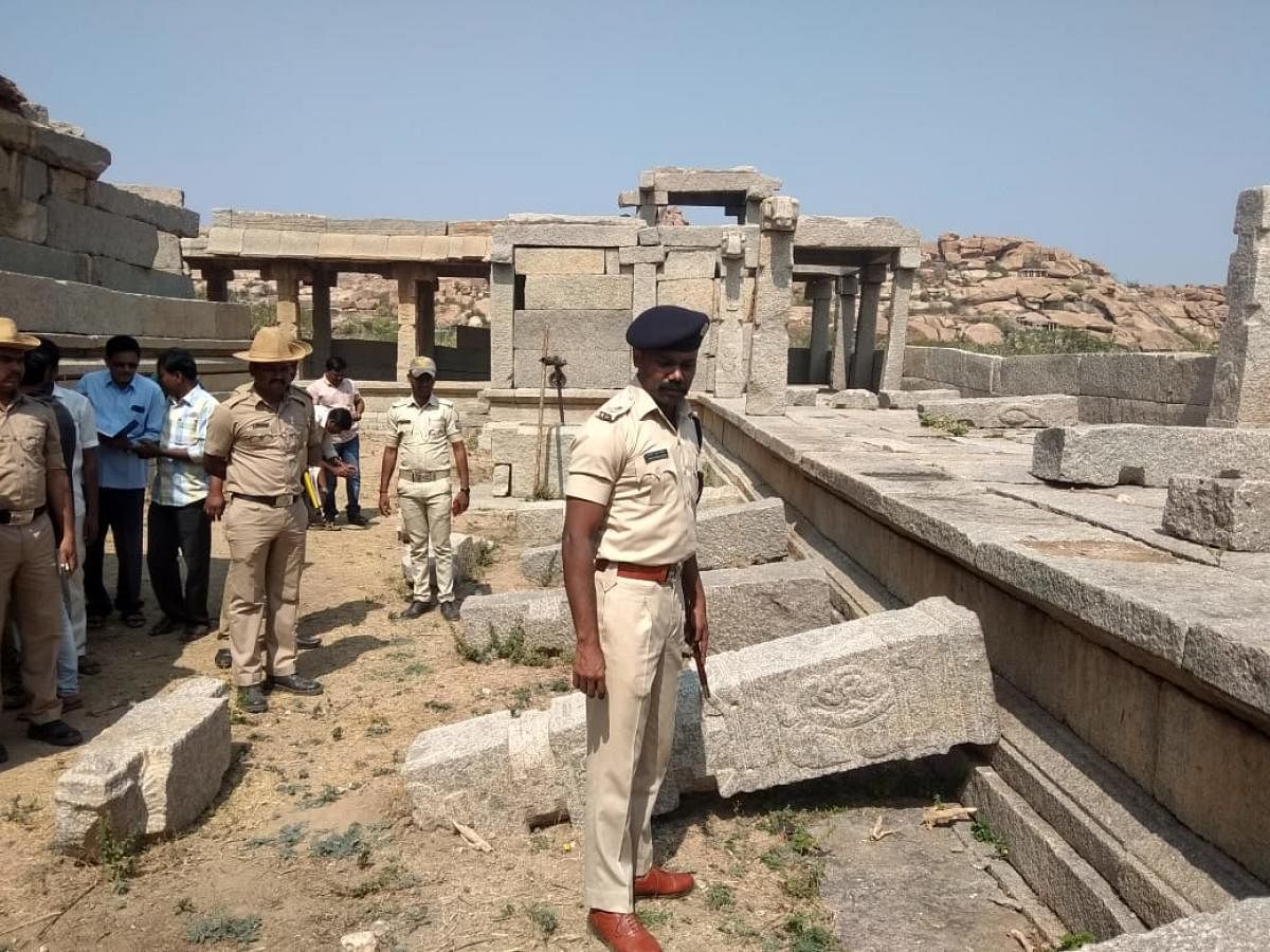 Police inspect the damage to the pillars in Hampi