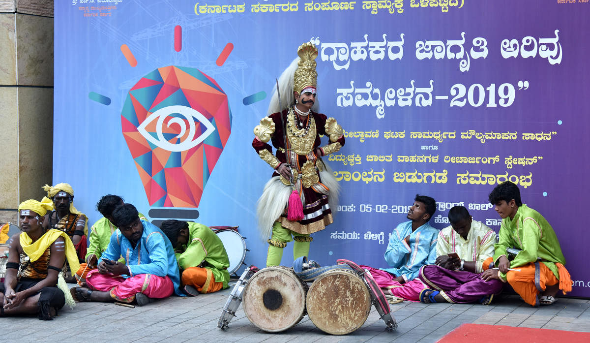 THE LONG WAIT: Folk artistes wait for Chief Minister H D Kumaraswamy for the inauguration of a customer vigilance awareness meet in Bengaluru on Tuesday. The programme was scheduled to start at 10.30 am and the chief minister arrived by 12.30 pm. DH Photo
