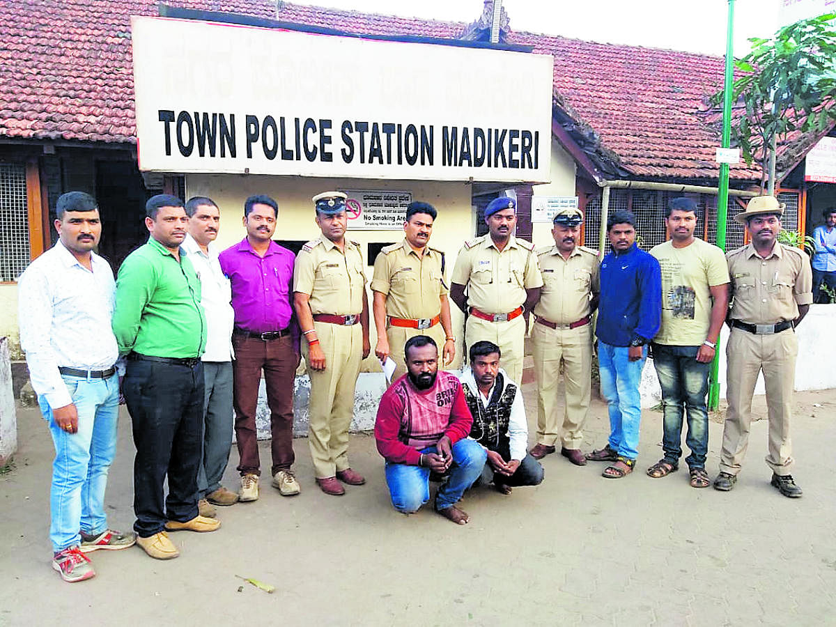 Madikeri Town police with the arrested, Mubarak and Syed Khalil, who had allegedly misused the name of District In-charge Minister Sa Ra Mahesh to cheat people, in Madikeri.