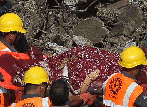 Members of the National Disaster Relief Force take out the body of a woman from the debris of a collapsed building in Mumbai, India, Friday, Sept. 27, 2013. The multi-story residential building collapsed in India's financial capital of Mumbai early Friday, killing at least three people and sending rescuers racing to reach dozens of people feared trapped in the rubble. AP Photo