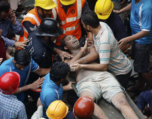 Rescue workers use a stretcher to carry a man who was rescued from the rubble at the site of a collapsed residential building in Mumbai Reuters Image