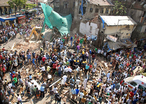 The crowd gather near a building that collapsed at Kamathipura in Mumbai on Saturday. PTI Photo