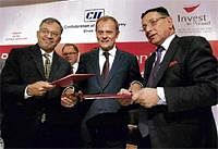 Poland Prime Minister Donald Tusk (centre) looks on as CII Karnataka chief Aroon Raman (L) exchanges MoU with Slawomir Mazman (right), President of Polish Information and Foreign Investment Agency, during the Polish-Indian Investment forum in Bangalore on Monday. PTI