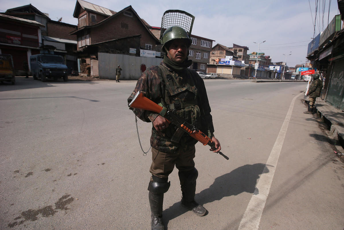 Indian Central Reserve Police Force (CRPF) personnel stand guard in front of closed shops during restrictions after Kashmiri separatist called for shutdown to protest the arrest of their leaders in Srinagar February 24, 2019. REUTERS/Danish Ismail