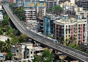 commuting relief: A Mumbai Metro train passes through a residential area during its first official safety trial run in Mumbai on Wednesday. PTI