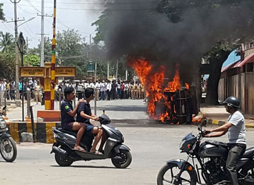 A vehicle bearing Tamil Nadu registration number was set afire during a protest in Mysuru on Monday. DH photo