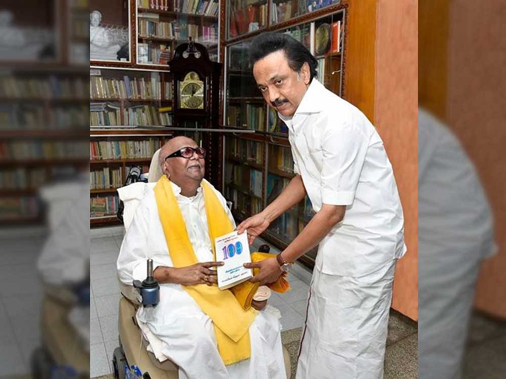 Son and DMK Acting President M K Stalin presenting a book to his father M Karunanidhi.