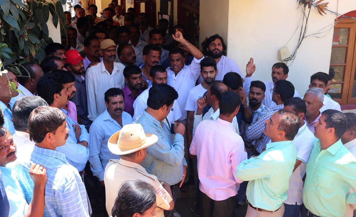 Coffee growers stage a protest in front of the office of CESC in Somwarpet on Monday.
