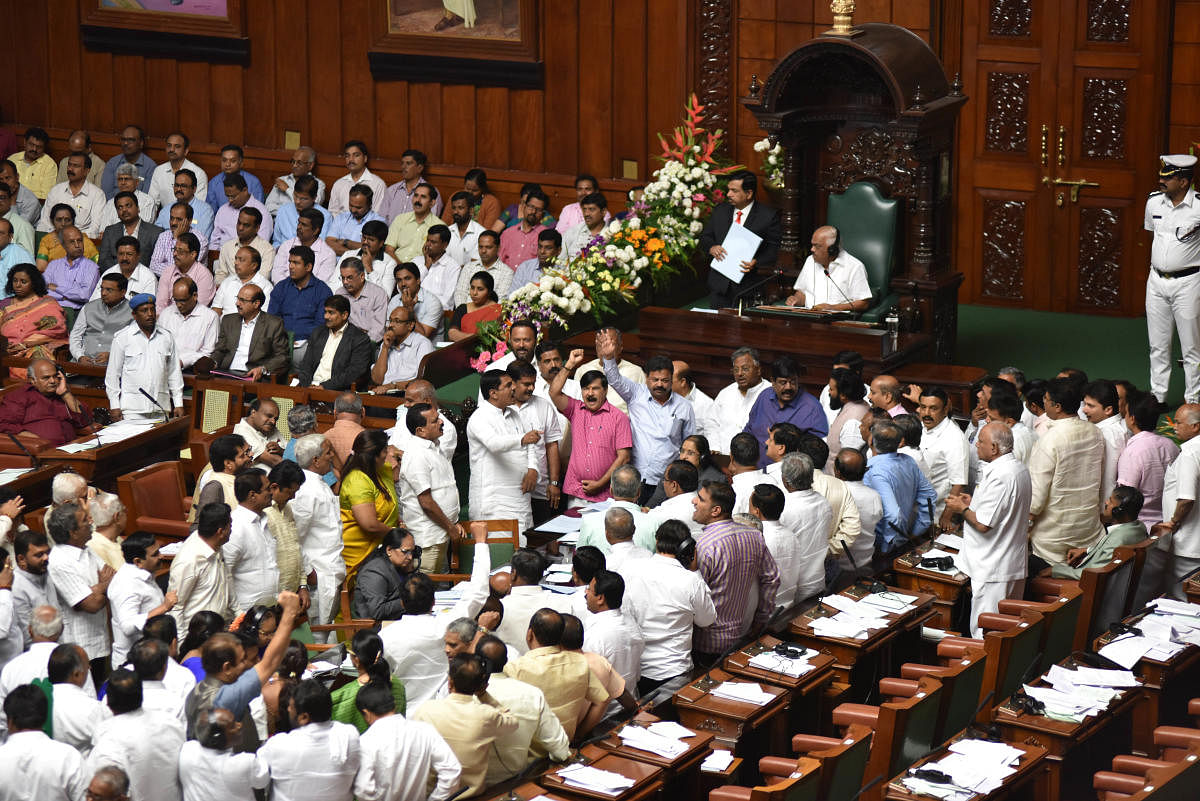 BJP legislators raise slogans in the Well of the House against constitution of an SIT to probe the audio tapes on 'Operation Lotus', in Vidhana Soudha, Bengaluru. DH Photo/ B H Shivakumar