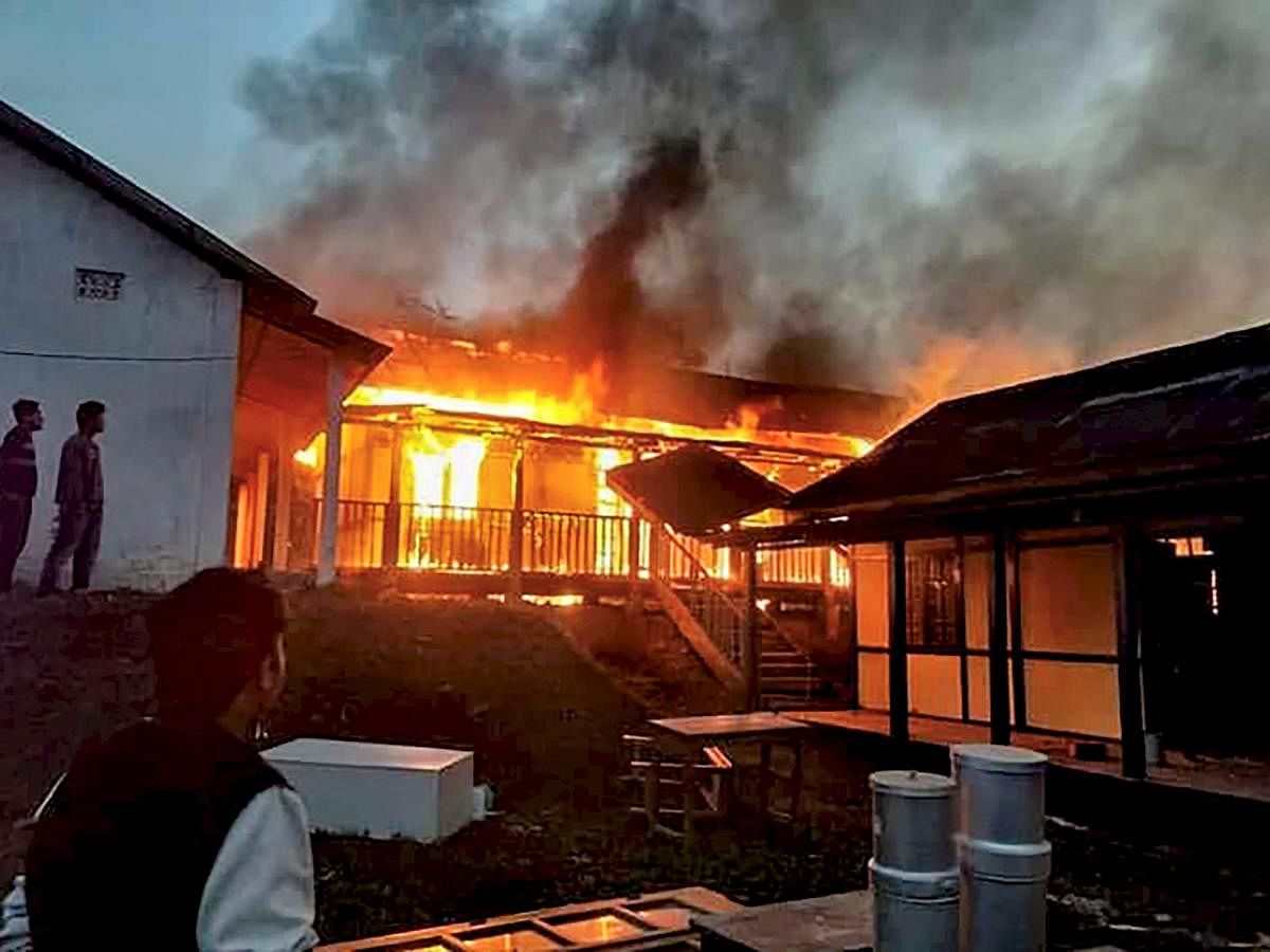 A building set on fire after a mob went on a rampage during a protest against the move to grant permanent resident certificates to six communities living in the state, in Itanagar on Sunday. PTI