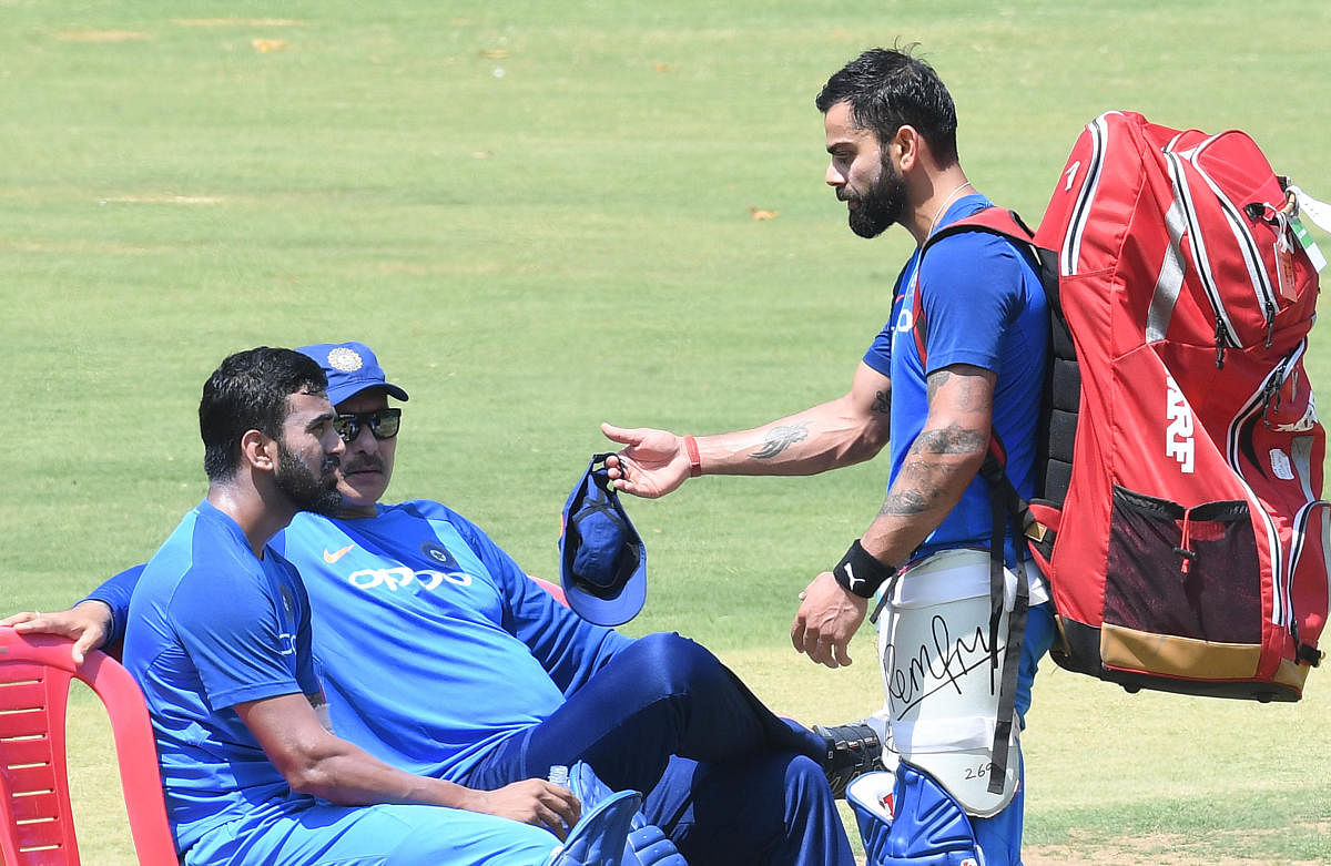 SERIOUS TALK: Indian captain Virat Kolhi (right) having a word with opener K L Rahul and head coach Ravi Shastri during their practice session at the M Chinnaswamy stadium in Bengaluru on Tuesday. DH Photo/ Srikanta Sharma R