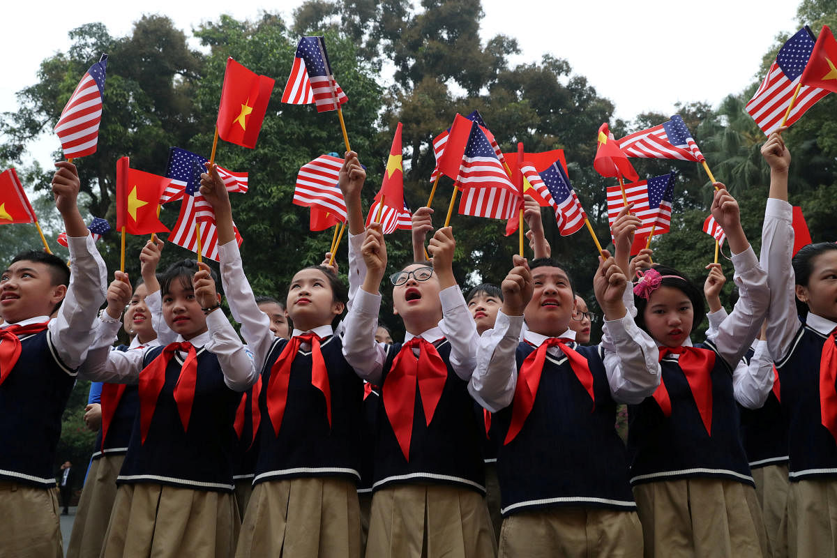 Students from Nguyen Du secondary school wave U.S. and Vietnam flags outside the Presidential Palace, as they wait to greet U.S. President Donald Trump, in Hanoi, Vietnam, February 27, 2019. REUTERS