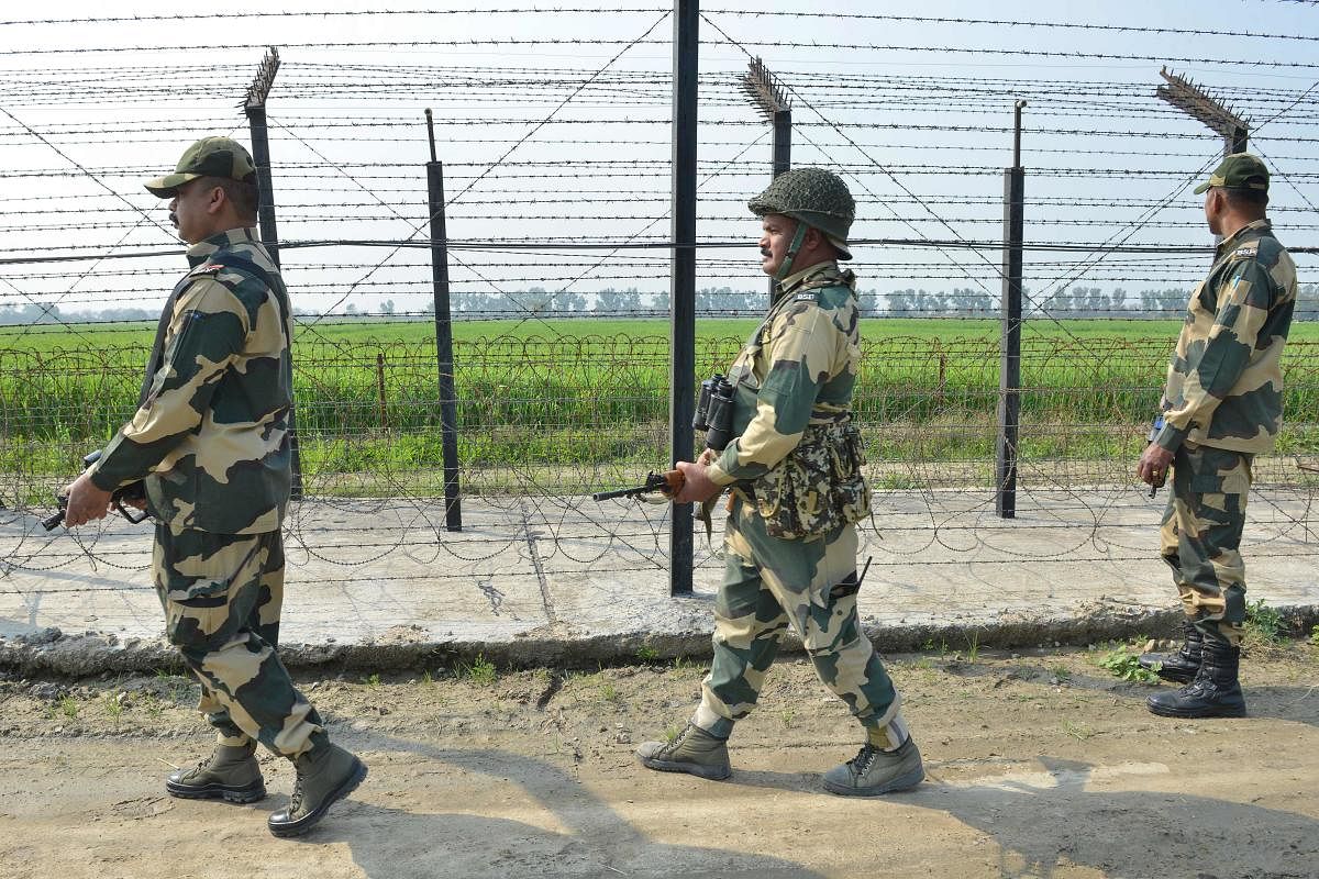 Border Security Force personnel walk along a fence at the India-Pakistan border on the outskirts of Amritsar on February 27, 2019. AFP