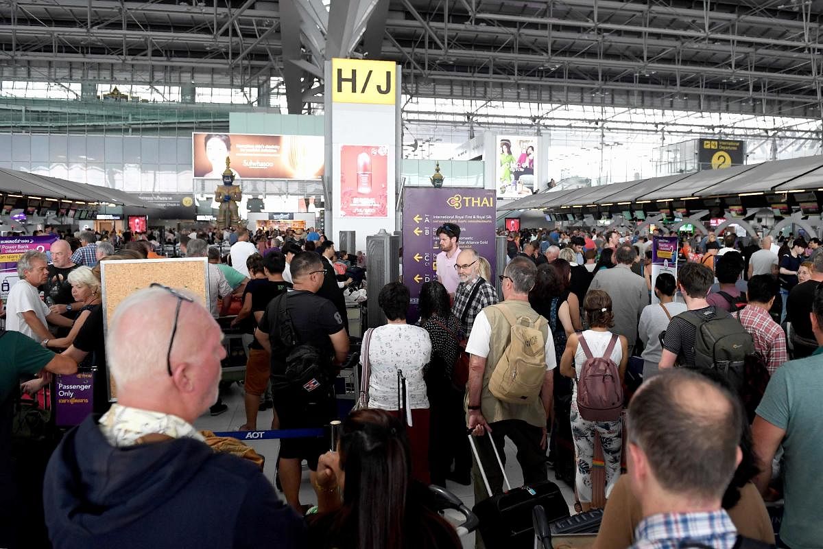 Stranded passengers wait at the check-in area at the Suvarnabhumi International Airport in Bangkok. (AFP Photo)