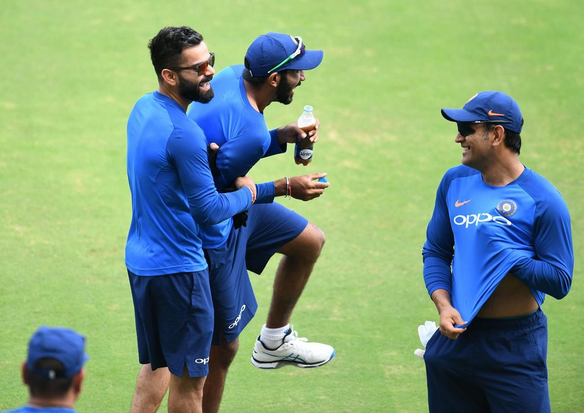 FUN AT WORK Indian captain Virat Kohli (left) in a playful mood with Jasprit Bumrah as MS Dhoni (R) looks on during a practice session in Hyderabad on Friday. AFP