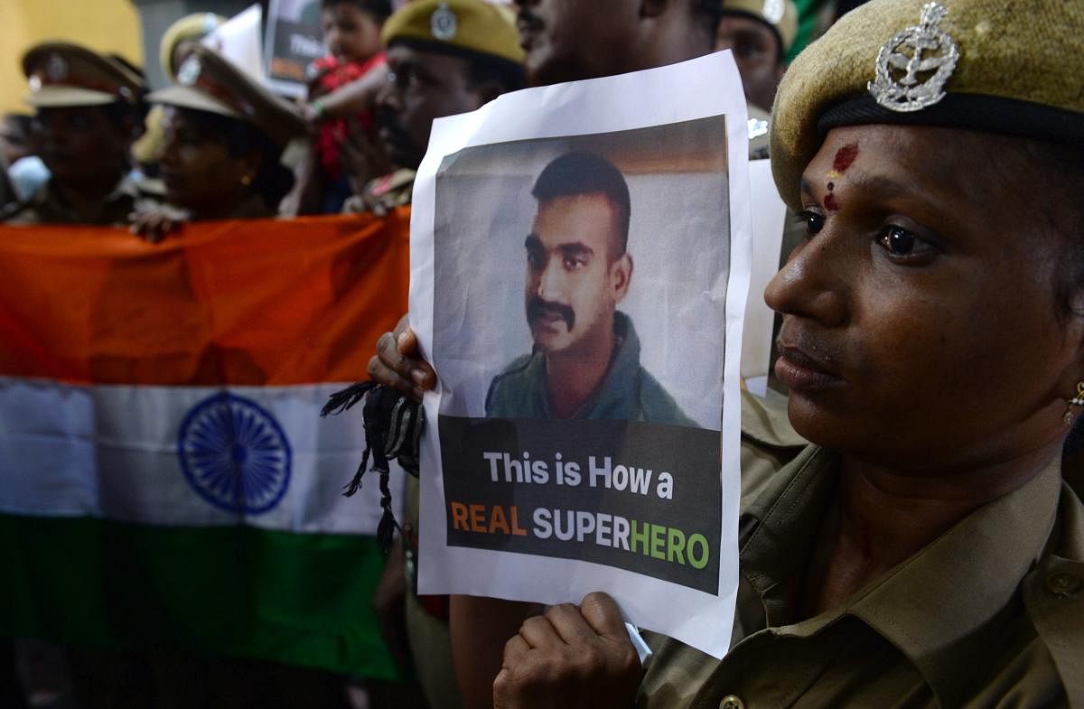 Indian security forces pose with the national flag and pictures of Indian Air Force pilot Abhinandan Varthaman during an event to pray for his return, at Kalikambal temple in Chennai. AFP photo