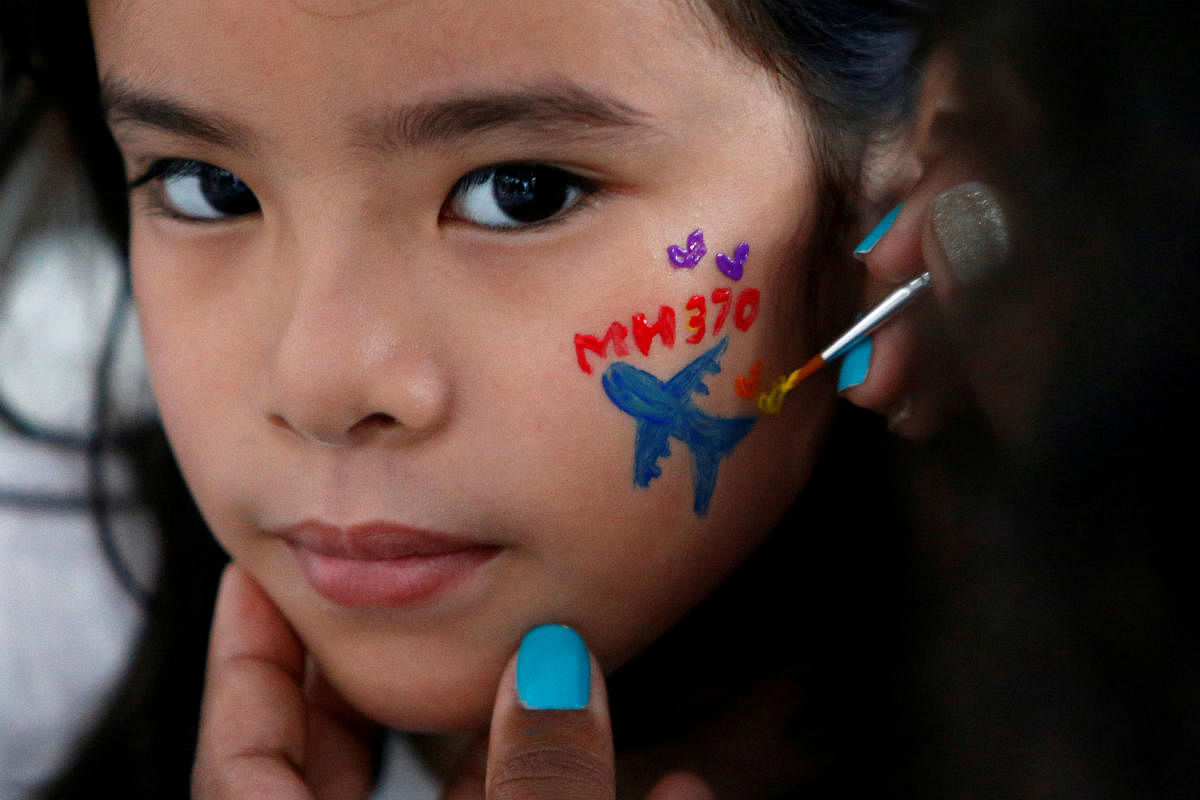 A girl gets her face painted during the fourth annual remembrance event for the missing Malaysia Airlines flight MH370, in Kuala Lumpur, Malaysia March 3, 2018. REUTERS/Lai Seng Sin