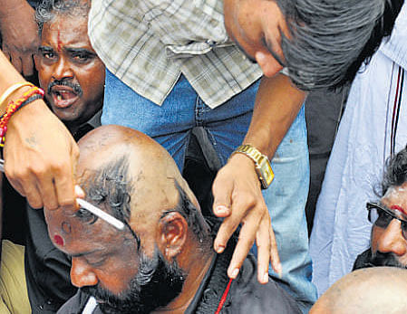 An AIADMK supporter gets his head shaved off as part of their protest against the conviction Jayalalitha in Coimbatore on Monday. PTI