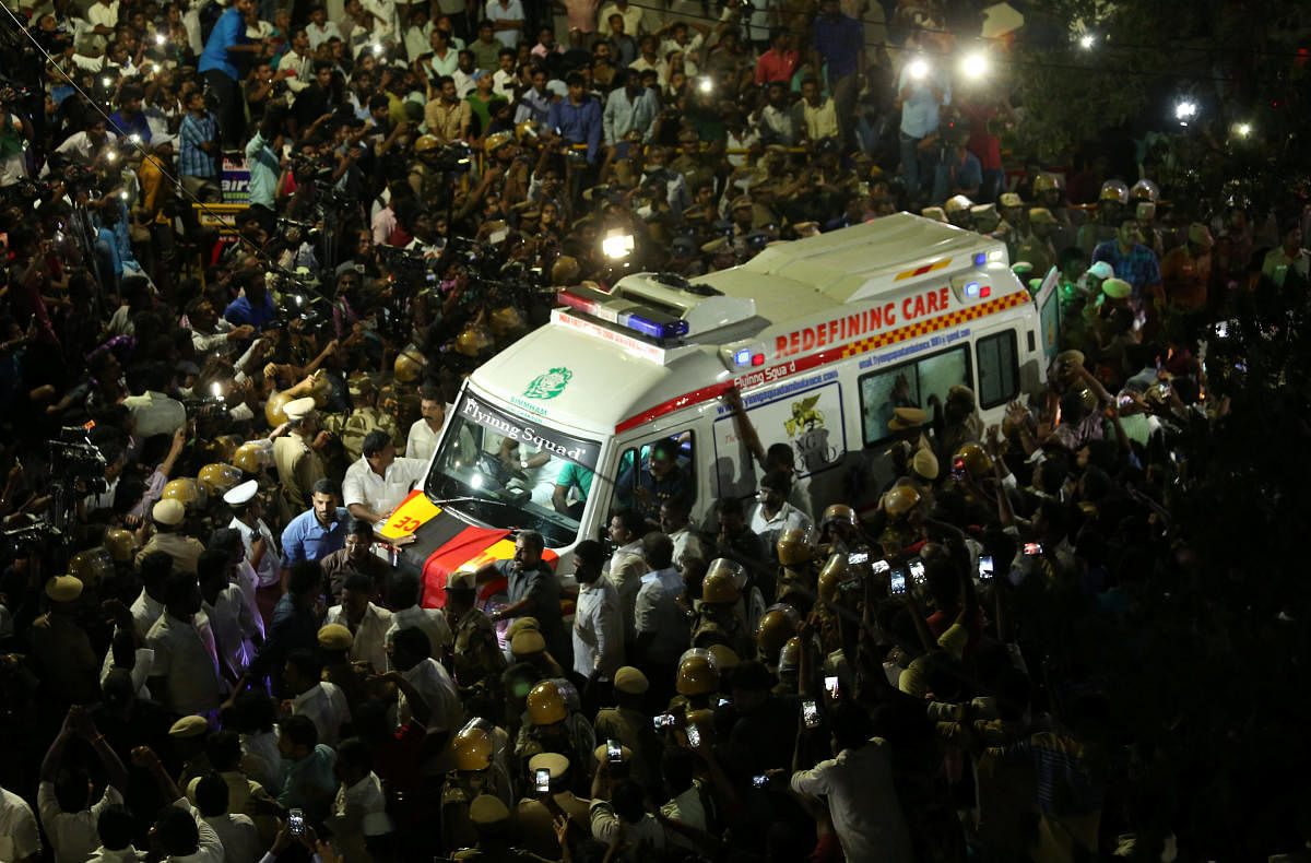 Supporters gather as an ambulance carrying the remains of Indian Tamil leader M. Karunanidhi. PTI Photo
