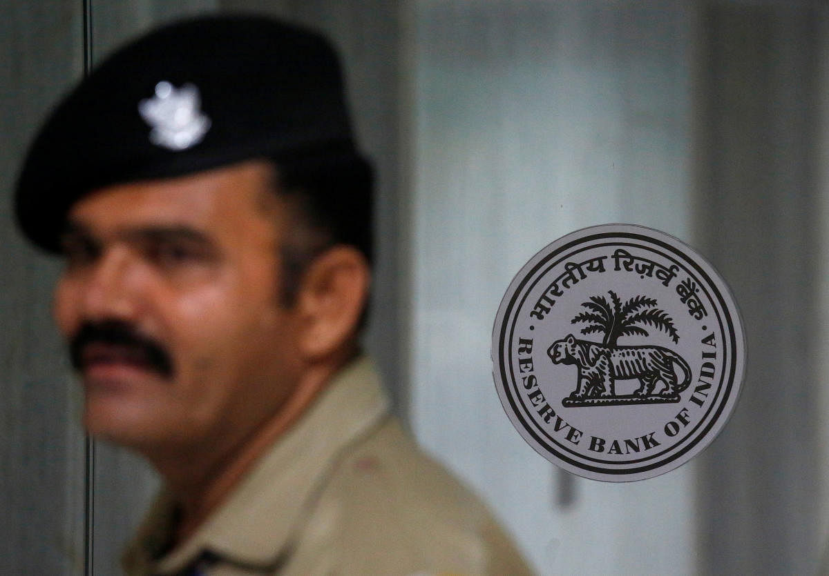 A security guard stands next to the logo of Reserve Bank of India (RBI) inside its headquarters in Mumbai. REUTERS