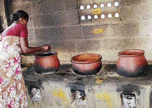 A 70-year-old Sagunthala quietly cleans clay utensils of various sizes near Karur-Madurai highway at Malaikovilur village in Tamil Nadu.  DH photo