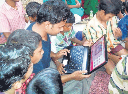 An NGO activist gives computer training to slum children in Bhubaneswar.