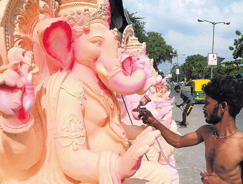 Artisans put the final touches to Ganesha idols in Ahmedabad.