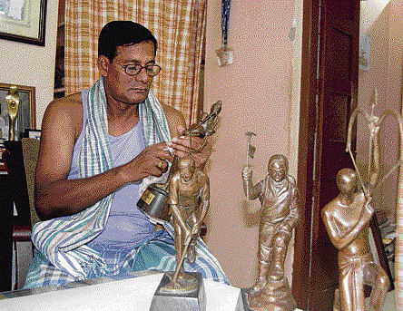 Sculptor-painter Gajendra Prasad Sahu with Arjuna and other sports award trophies.