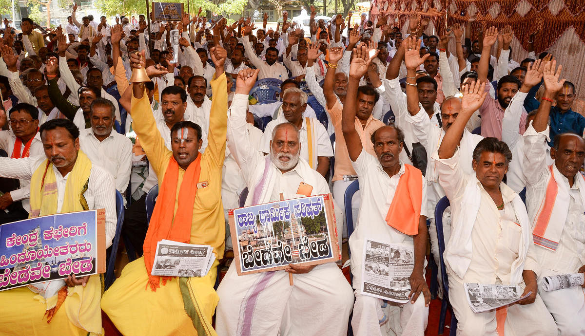 Priests stage a protest seeking government meet their various demands at Freedom Park in Bengaluru on Thursday. DH Photo