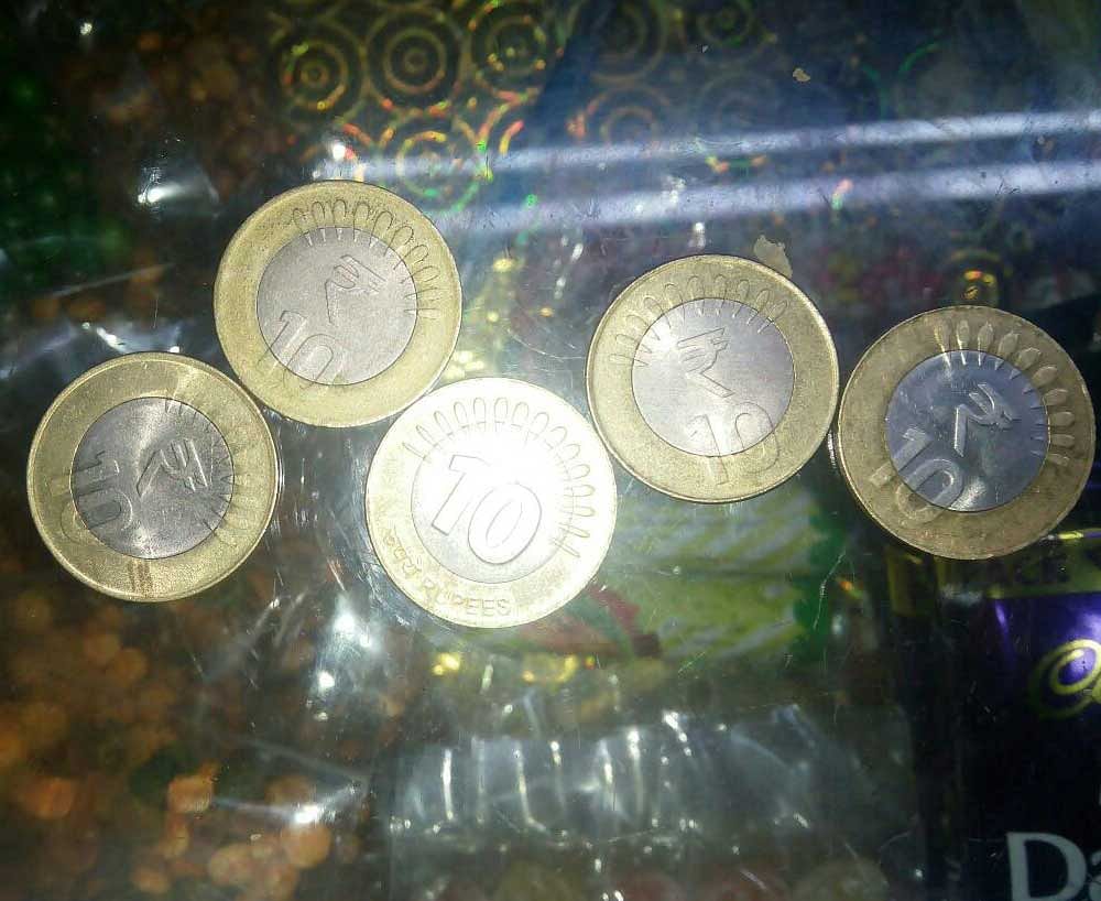 Two variants of Rs 10 coins. Among these one does not have rupee symbol and having more than ten bars around the number 10. (DH Photo/Ajmal)