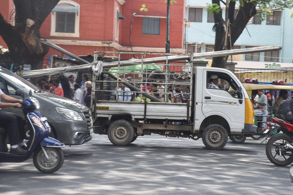 Goods vehicles in Bengaluru carry steel pipes jutting out and posing dangers to road users. DH Photos by S K Dinesh