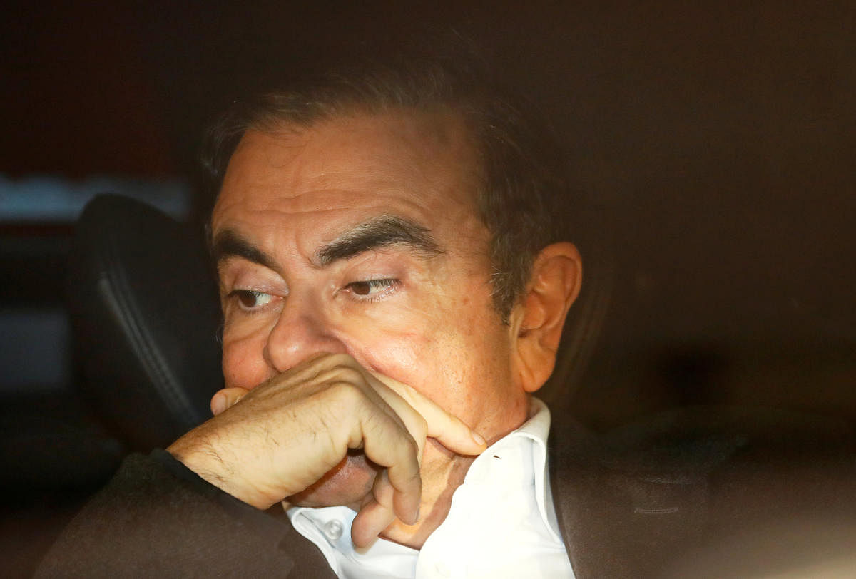 Former Nissan Motor Chairman Carlos Ghosn sits inside a car as he leaves his lawyer's office after being released on bail from Tokyo Detention House, in Tokyo. Reuters file photo