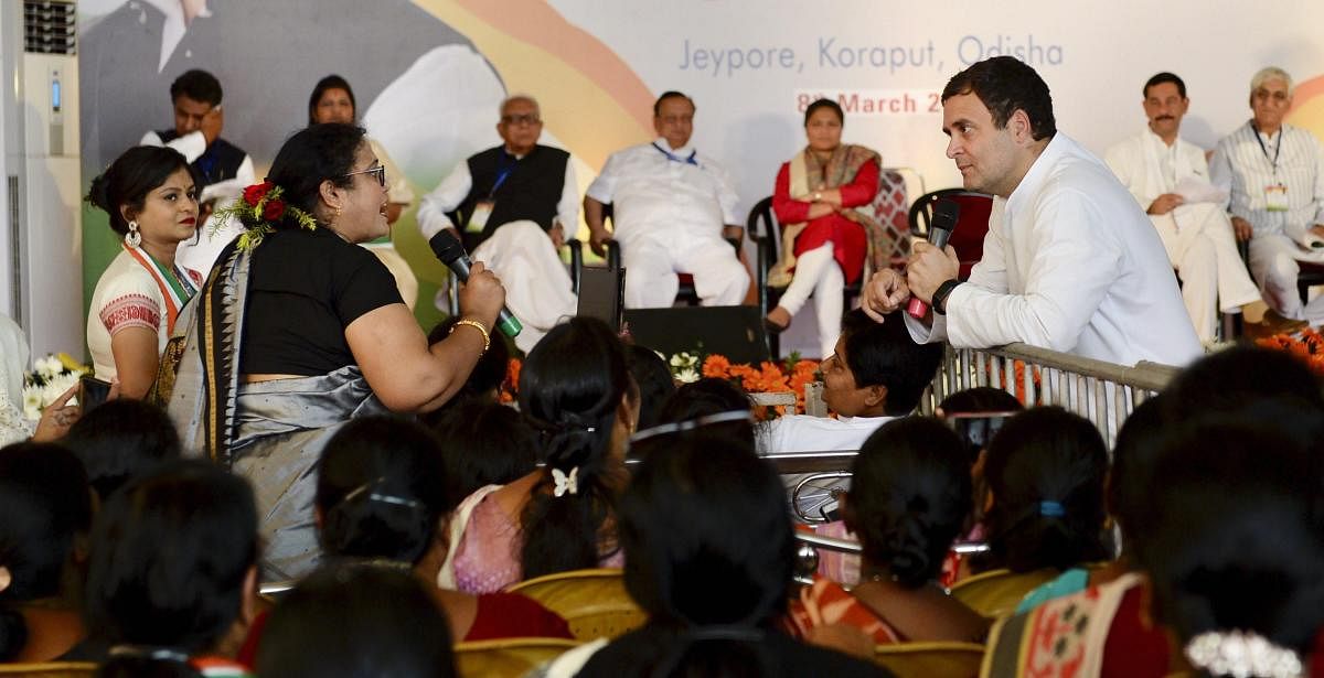 Congress President Rahul Gandhi interacts with a woman at a convention, in Jeypore town of Koraput. PTI