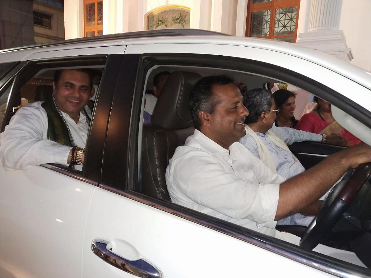 Minister for Urban Development U T Khader drives the former chief minister Siddaramaiah to the Congress rally venue after they were forced to abandon their official cars following the enforcement of Model Code of Conduct, in Udupi on Sunday evening. DH PH