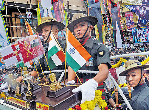 Soldiers take out a procesion on the occasion of Kargil Day as Rajinikanth fans gather in front of Nataraj theatre in Bengaluru on Friday. DH PHOTO
