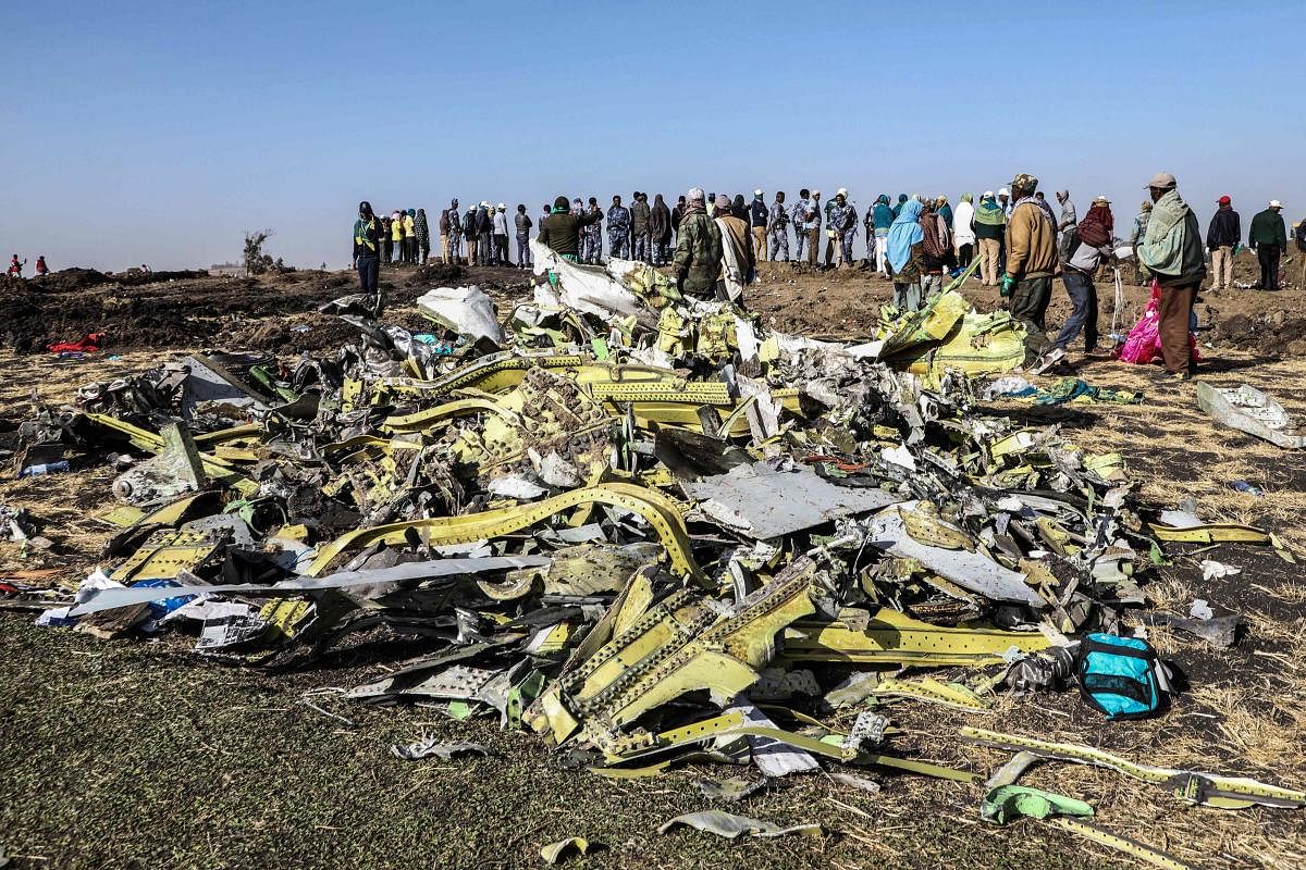 People stand near collected debris at the crash site of Ethiopia Airlines near Bishoftu, a town some 60 kilometres southeast of Addis Ababa, Ethiopia. AFP
