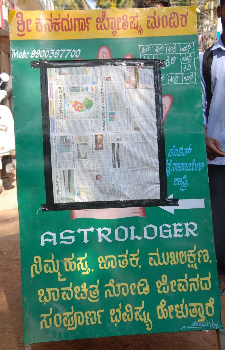 The board in front of an astrologer's shop that has been covered by election officials in Mandya. dh photo