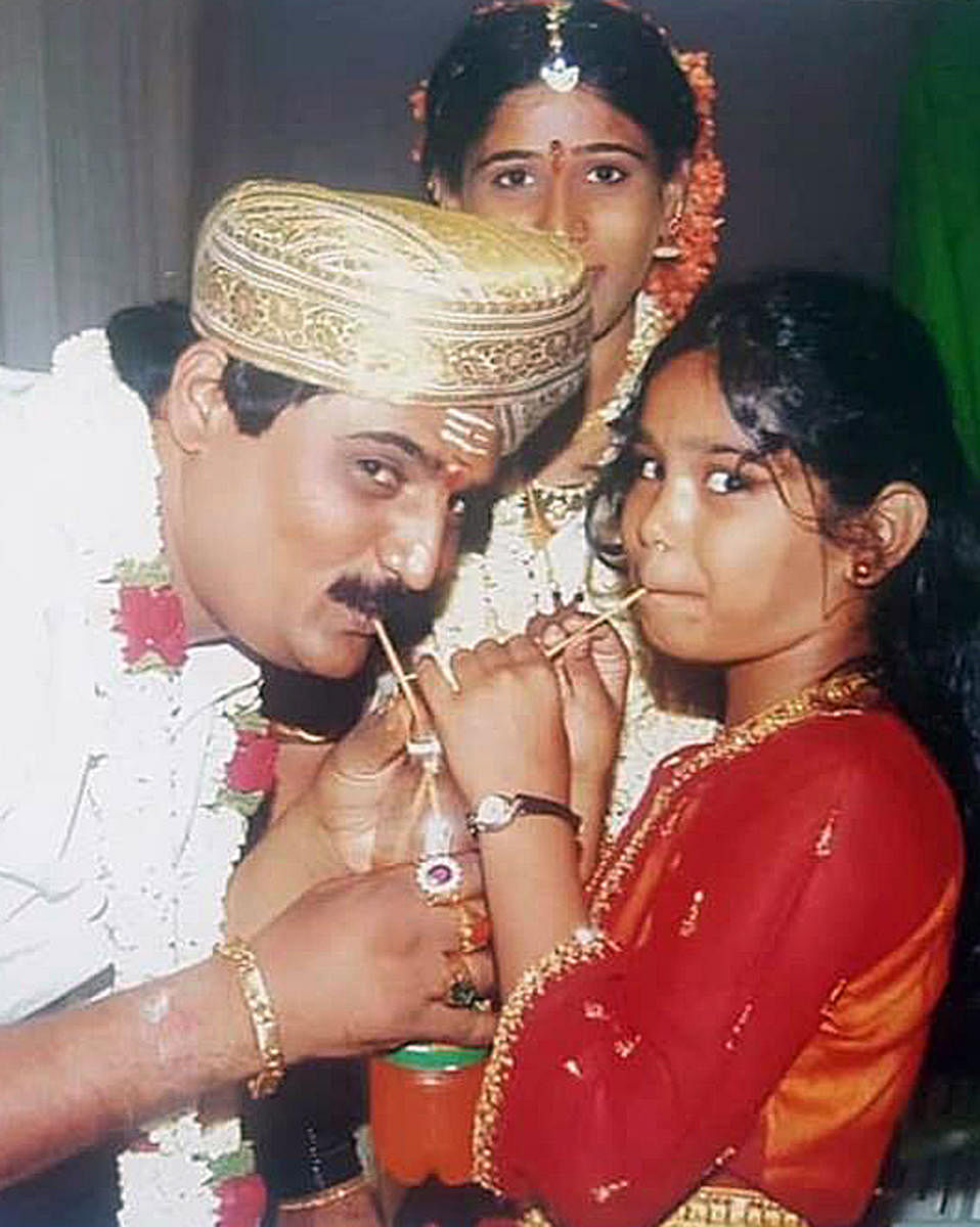 Gangster Lakshmana with Varshini (aged 8) as his wife Chitra looks on.