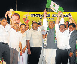 Former chief minister H D Kumaraswamy welcoms former minister Nagaraj Shetty by handing over the party flag, at the JD(S) convention in Mangalore on Monday.