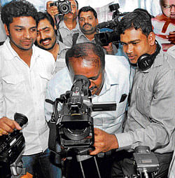 in focus Former chief minister H D Kumaraswamy looks through a camera after inaugurating the JD(S) media centre in Bangalore on Wednesday. DH Photo