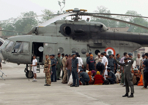 Pilgrims rescued from Badrinath alight from a helicopter at Jolly Grant airport in Dehradun following flood and landslides in Uttarakhand. PTI Photo
