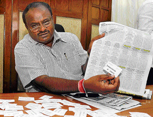Former chief minister H D Kumaraswamy shows single-digit  lottery tickets at a press meet on Friday in Bangalore. DH Photo