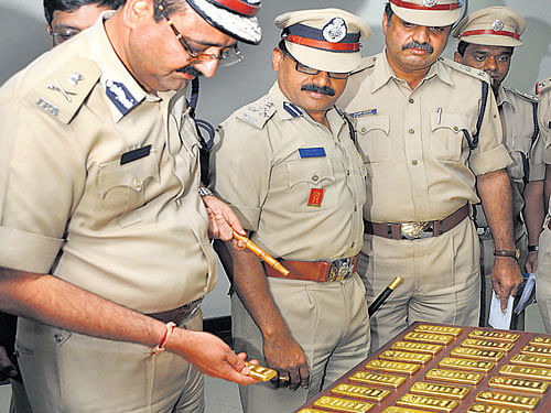 City Police Commissioner Raghavendra Auradkar and other police officers with the seized gold biscuits in Bangalore on Saturday. DH Photo