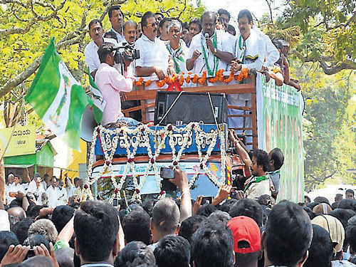State JD(S) president H D Kumaraswamy speaks at a public rally, in Mandya, on Monday. JD(S) candidate C S Puttaraju and others are seen. DH Photo