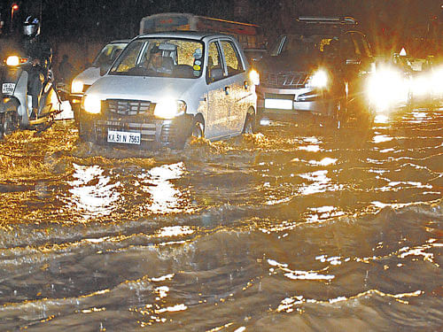 Motorists wade through the water-logged Old Airport road near Command Hospital in Bangalore on Saturday. DH Photo/ S K Dinesh