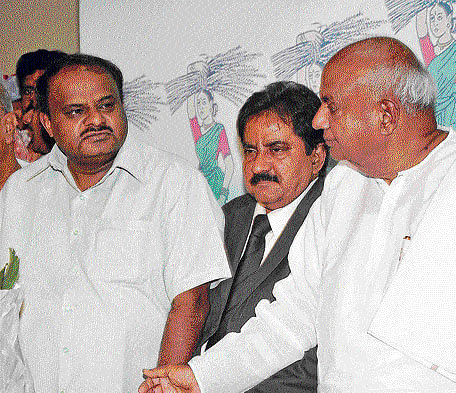 JD(S) national secretary Zafrulla Khan (centre) and national  president Deve Gowda congratulate Kumaraswamy on his reinstatement as state party president on Thursday. dh photo