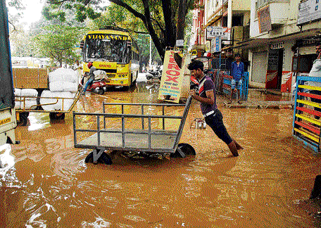 People struggle to move through waterlogged roads in Gandhinagar after heavy rainfall in City on Tuesday. KPN