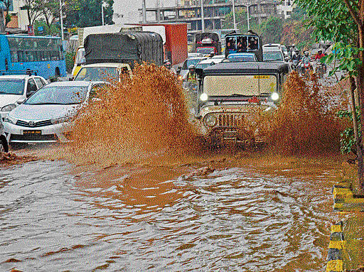 Vehicles move along waterlogged roads near Nagarabhavi in Bengaluru on Monday. DH Photo/ M S MANJUNATH